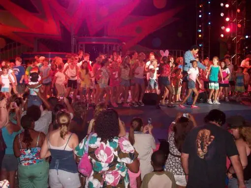 A crowd of people standing around in front of a stage.