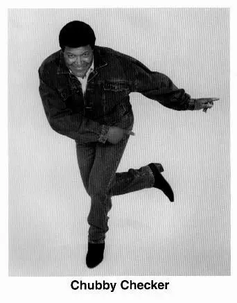 A man in jeans and jacket jumping up.